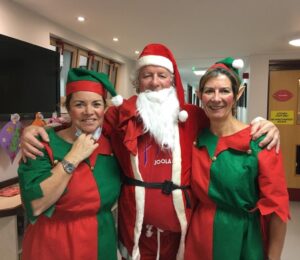 Image of two EYECAN staff members dressed as elves and a volunteer dressed as Santa