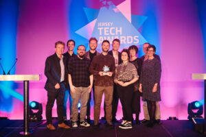  Image of the EYECAN team with their public Sector/Charity award at the Jersey Tech Awards. Chris Frost from EYECAN is holding the award with the EYECAN team behind him.