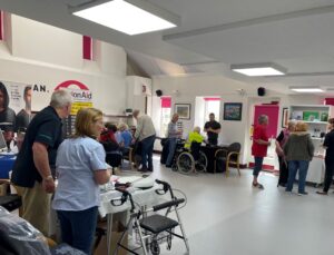 Image shows the main hall at Westlea Centre busy with visitors, staff and volunteers. Exhibitors are showing visitors equipment that is displayed on their stands.