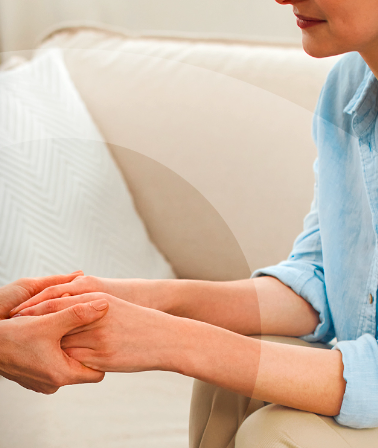 Image of a woman comforting another young woman by holding both her hands as they are seated on a couch. The following words are written in white: 10th October, World Mental Health Day