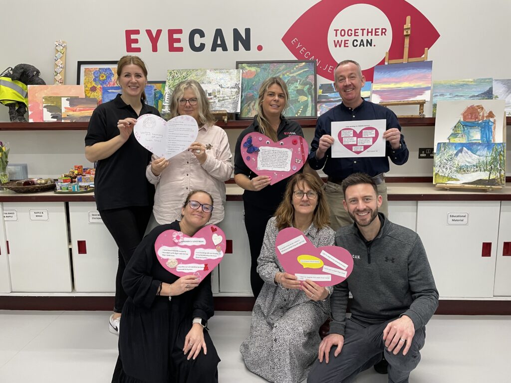 Staff at EYECAN pose for a photo of all of them displaying their cut out hearts for Valentine's Day.